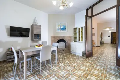a dining room with a table and chairs and a fireplace at Casa Trionfante in Santa Flavia