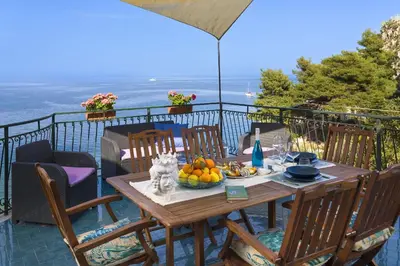 a table with a bowl of fruit on a balcony at Terrazza Trionfante in Santa Flavia