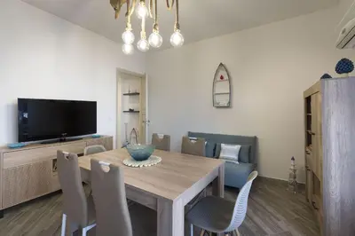 a dining room with a wooden table and chairs at Terrazza Trionfante in Santa Flavia