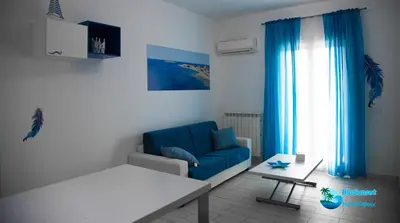 a living room with a blue couch and a table at BluSunset Home Capaci in Capaci