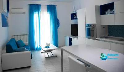a living room with a table and a blue chair at BluSunset Home Capaci in Capaci