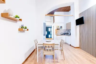 a kitchen and dining room with a table and chairs at Cappuccini 62 House in Palermo