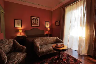 a bedroom with a bed and a chair and a window at La dimora del genio in Palermo