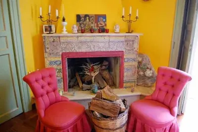 a living room with two red chairs and a fireplace at La dimora del genio in Palermo