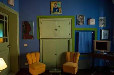a room with two chairs and a cabinet and a desk at La dimora del genio in Palermo