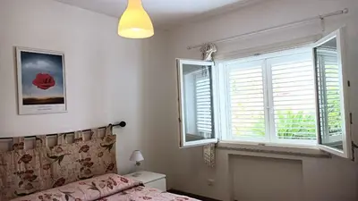 a bedroom with a bed and two windows at Villa Ginevra in Mondello