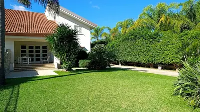 a house with a yard with green grass and trees at Villa Ginevra in Mondello