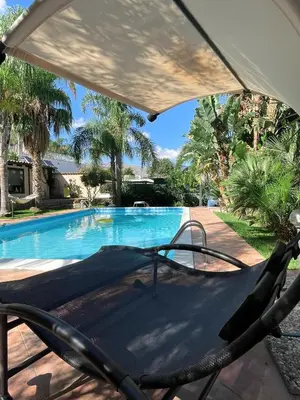 a house with a window next to a swimming pool at VillaLietta in Capaci