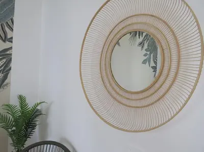 a round mirror on a wall next to a plant at Relax nel verde- GioDaPi Palm in Palermo