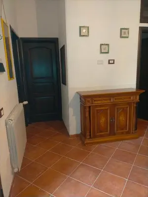 a room with a door and a tiled floor with a wooden cabinet at Menzel el Emir in Misilmeri