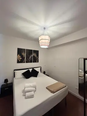 a bedroom with a white bed with a light at Mondello suite apartment in Mondello