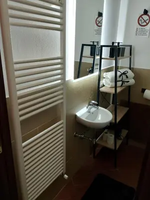 a small bathroom with a sink and a mirror at Mondello suite apartment in Mondello