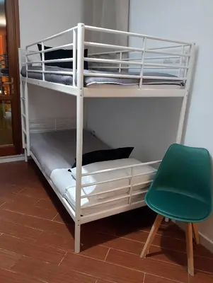 a bunk bed in a room with a green chair at Mondello suite apartment in Mondello