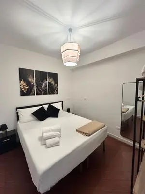a bedroom with a large white bed with a pendant light at Mondello suite apartment in Mondello