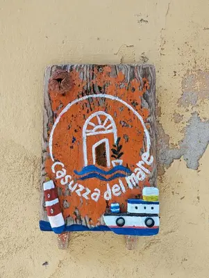 a sign on the side of a wall with a door at Casuzza del mare in Castellammare del Golfo