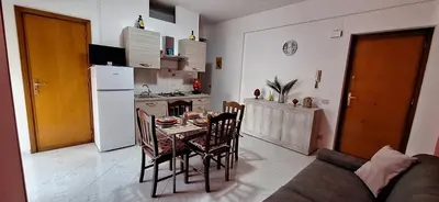 a kitchen with a table and chairs and a kitchen with a refrigerator at Sweet Dreams a casa di Alex in Palermo