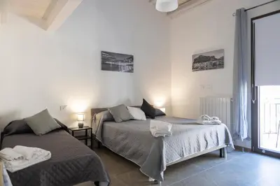 a bedroom with two beds and a window at L'Oasi del Tirreno in Lascari