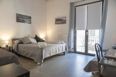 a bedroom with a bed and a large window at L'Oasi del Tirreno in Lascari