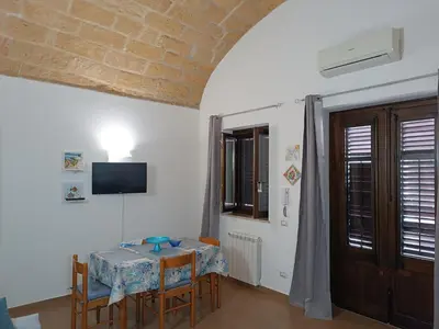 a dining room with a table and chairs and a tv at Casa Atlanna in Terrasini