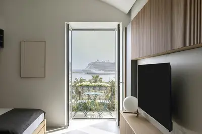 a bedroom with a bed and a large window with a cruise ship at Trinacria Marina Apartment in Palermo