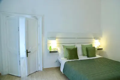 a bedroom with a large bed with green sheets and pillows at Cara Palermo in Palermo