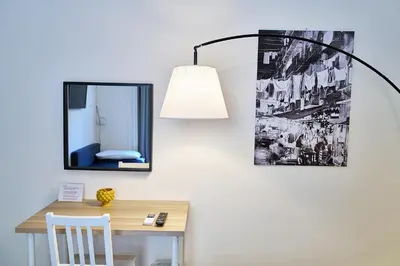 a desk with a lamp and a mirror on a wall at Cara Palermo in Palermo