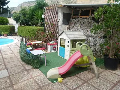 a playground with a slide next to a house at Villa Aurora Appartamento in villa con piscina in Bagheria