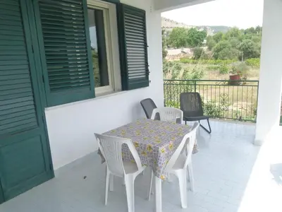 a patio with a table and chairs on a balcony at Villa Aurora Appartamento in villa con piscina in Bagheria