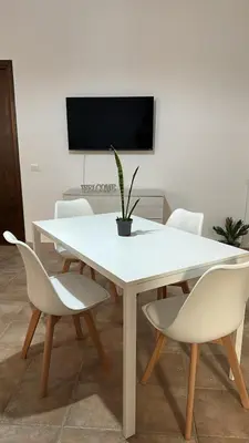 a white table and chairs with a potted plant on it at Domus Mea Apartments in Carini