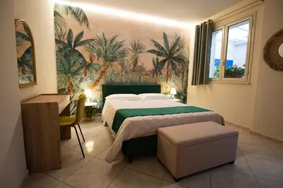 a bedroom with a bed with a green comforter at RelaxTime Casa Vacanze in Palermo