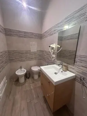 a bathroom with a sink and a toilet and a mirror at Emanuela Home in Palermo