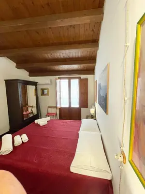 a bedroom with a large red bed with white pillows at House Quattro Canti in Palermo
