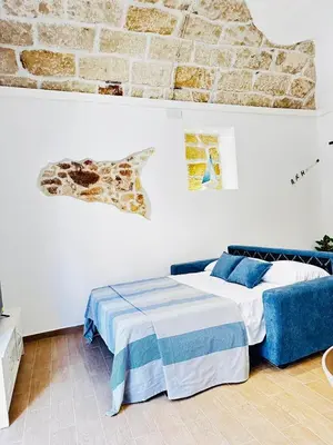 a bedroom with a bed and a brick wall at Sicilia biedda casa vacanze in Terrasini