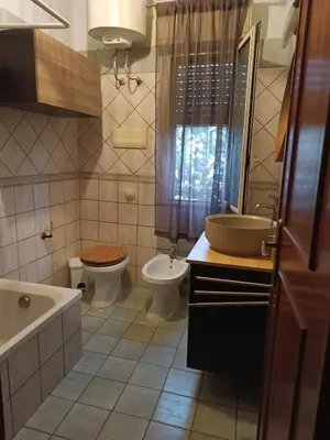 a bathroom with a toilet and a sink and a tub at House Ninì in Palermo