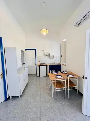 a large kitchen with a table and chairs in it at Terrazza Vitaloca in Scopello