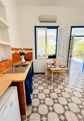 a kitchen with a sink and a table with chairs at Terrazza Vitaloca in Scopello