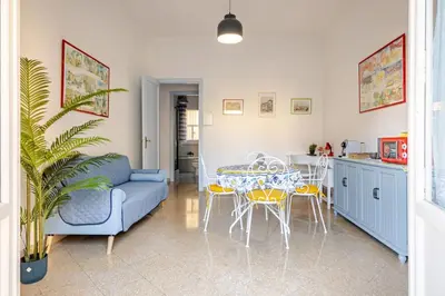 a living room with a blue couch and a table and chairs at AL Qanat di Notarbartolo in Palermo