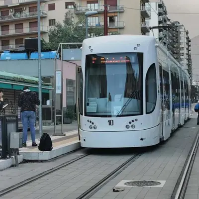 a white tram is stopped at a train station at AL Qanat di Notarbartolo in Palermo