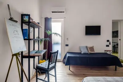 a bedroom with a bed and a chair in a room at Azizò in Palermo