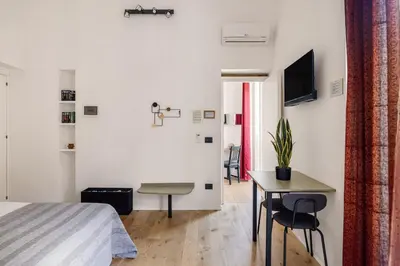 a bedroom with a bed and a table with chairs at Azizò in Palermo