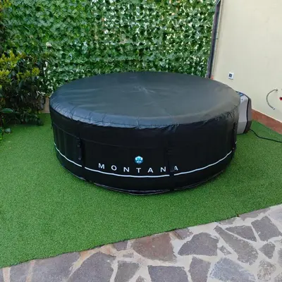 a round black trampoline sitting on the grass at Casa Carini - Villa Vacanze sul Mare con piscina idromassaggio in Carini