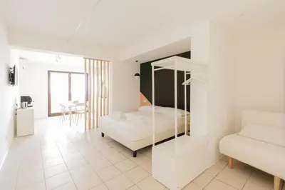 a white bedroom with a bed and a couch at Visitsicilia Vasile 9 in Castellammare del Golfo