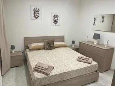 a bedroom with a large bed and two night stands at Ginevra House in Palermo
