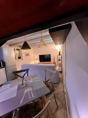 a living room with a table and chairs and a kitchen at Sisidda Home in Palermo