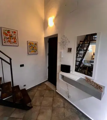 a hallway with a mirror on the wall and a window at Sisidda Home in Palermo