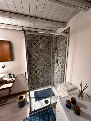 a shower with a glass door in a bathroom at Sisidda Home in Palermo