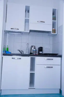 a white kitchen with white cabinets and a sink at apartment by the sea Mondello beach in Palermo