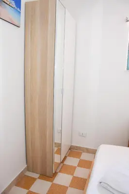 a bedroom with a bed and a glass door at apartment by the sea Mondello beach in Palermo