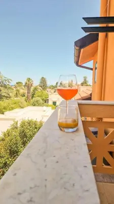 a wine glass sitting on a ledge on a balcony at apartment by the sea Mondello beach in Palermo