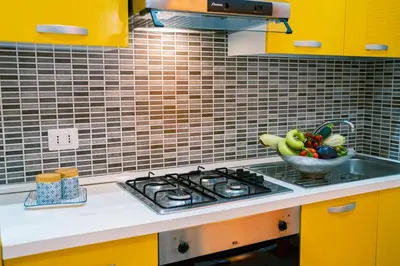 a kitchen with a sink and a bowl of fruit at Appartamenti Bellini in Castellammare del Golfo